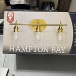 Hampton Bay Pavlen 24 In. 3-LIGHTS Antique Brass Vanity With Clear Glass. Fixed Price $45.00.